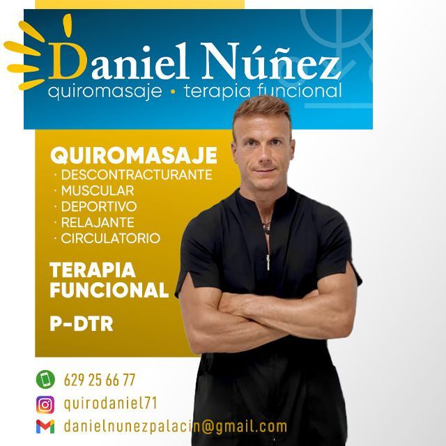 Una sala de terapia de masajes con mesa de masajes, estantes de almacenamiento, escritorio y silla.