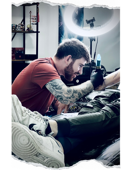 Un homme se fait tatouer sur le bras d'une personne.