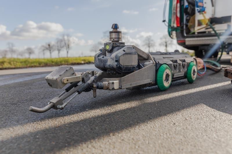 Ein Roboter sitzt am Straßenrand neben einem Lieferwagen.