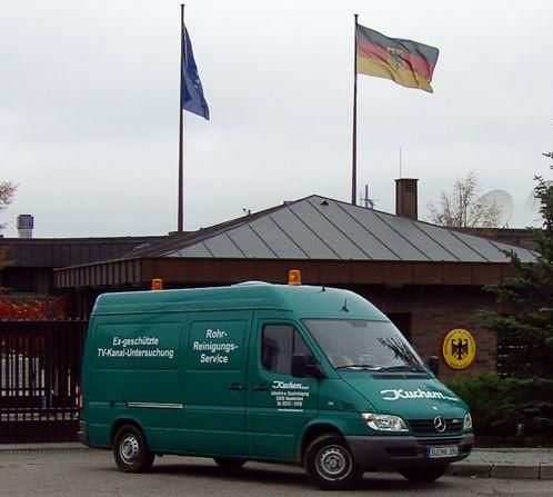 Ein grüner Lieferwagen steht vor einem Gebäude