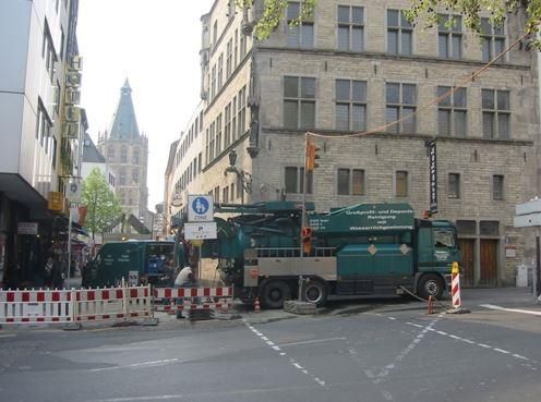 Ein grüner LKW steht mitten auf einer Stadtstraße