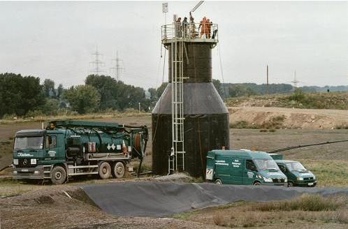 Eine Gruppe von Menschen steht auf einem Turm neben einem LKW