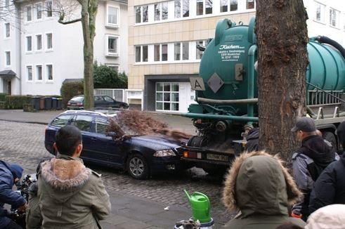 Eine Gruppe von Menschen steht vor einem LKW, auf dessen Rückseite ein steht