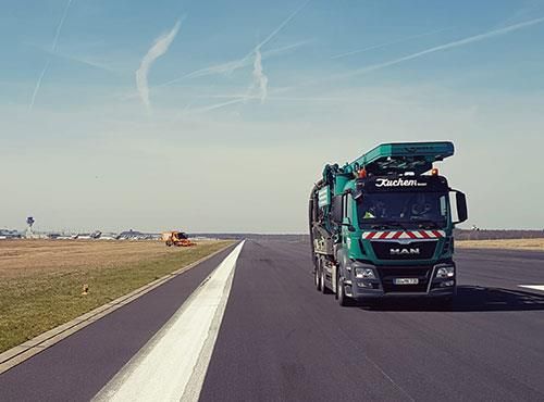 Ein grüner Lastwagen fährt auf einer Autobahn.