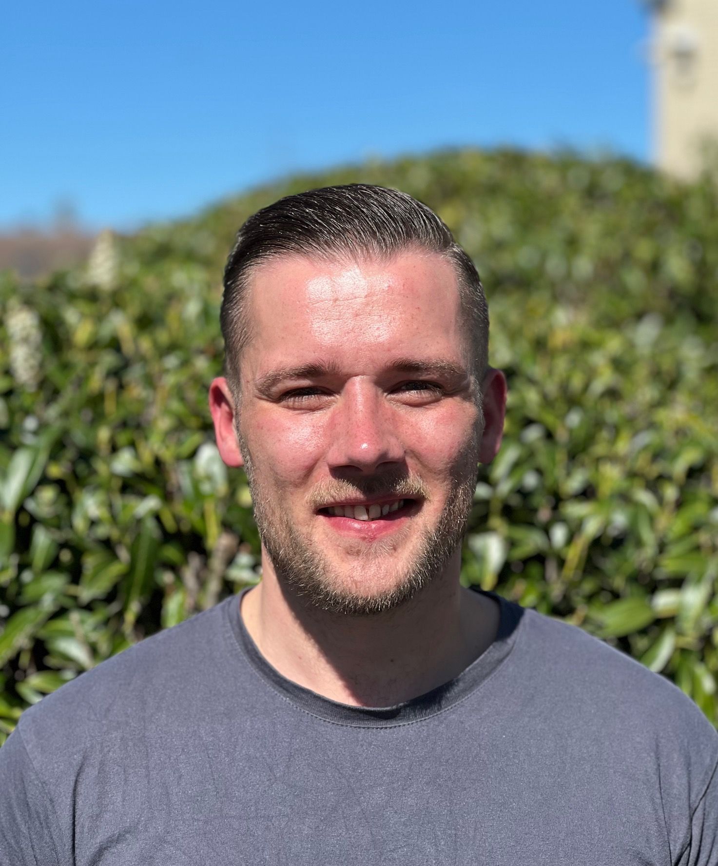 Eine Nahaufnahme des Gesichts eines Mannes vor einem grünen Lieferwagen.