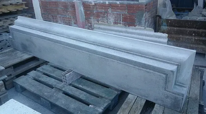 Elemento arquitectónico de hormigón gris sobre palets de madera.