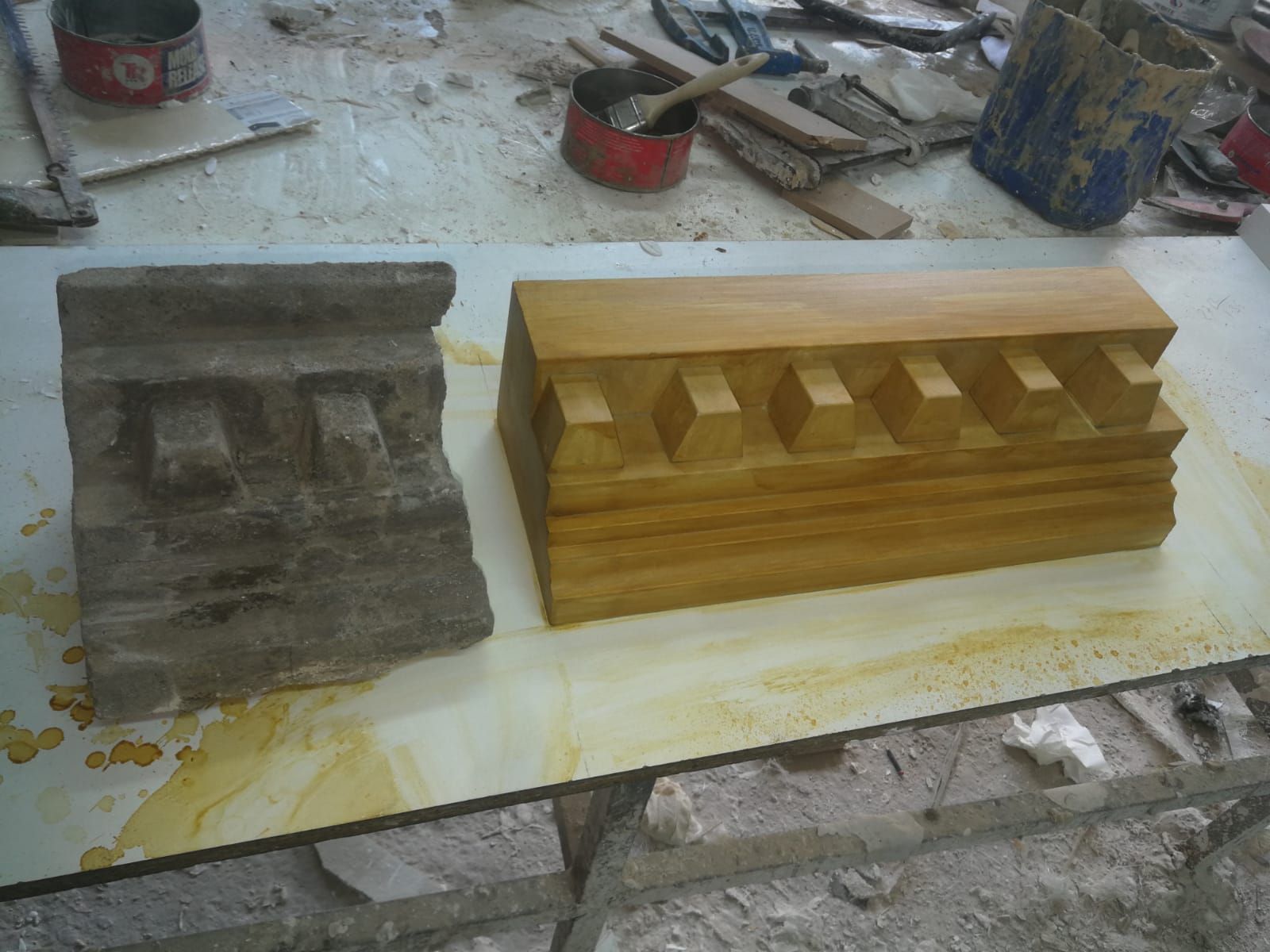 Dos bloques de madera tallada, uno junto al otro. Uno es gris y desgastado.