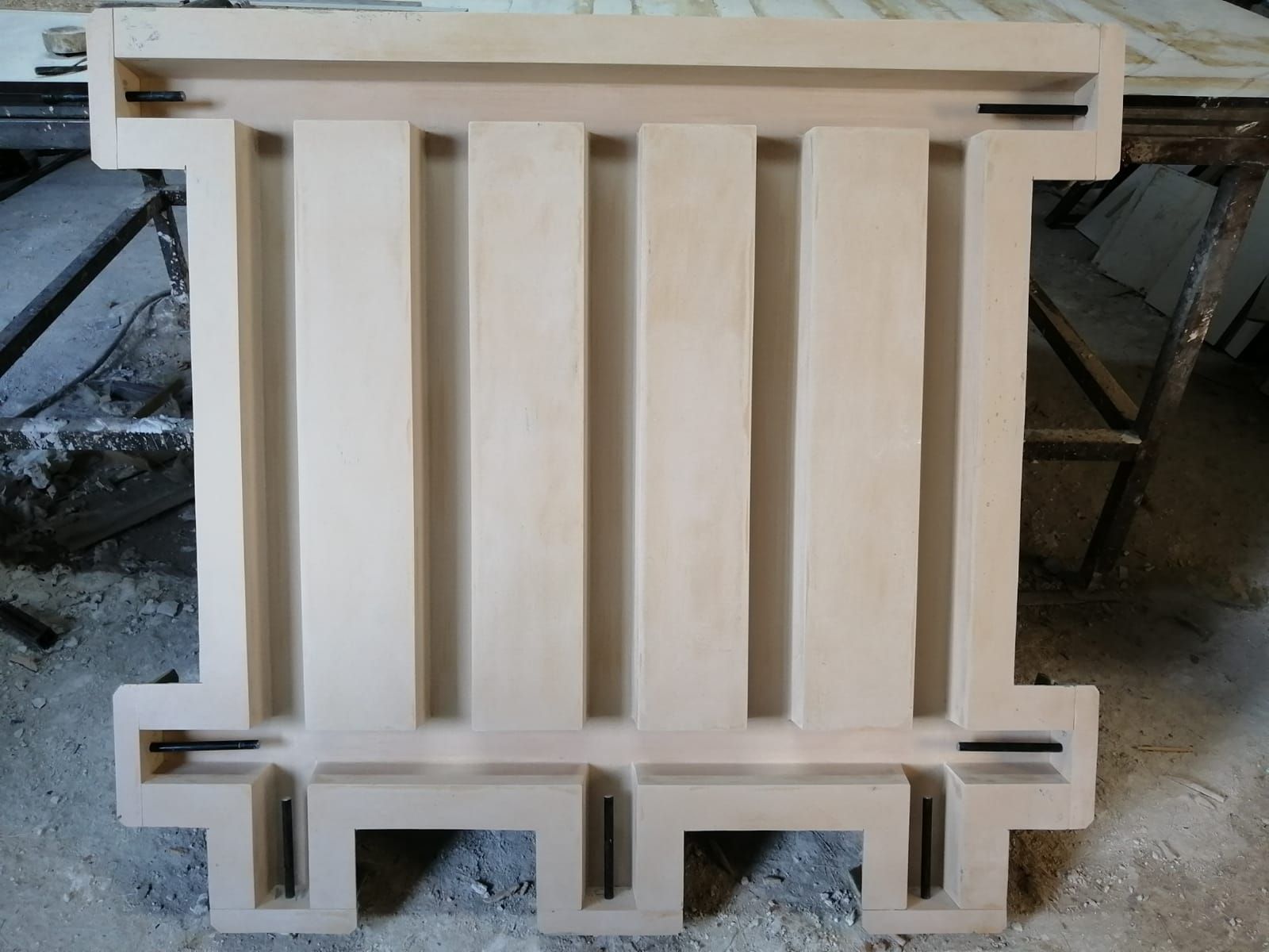 Forma de madera beige con pilares verticales y soportes horizontales.