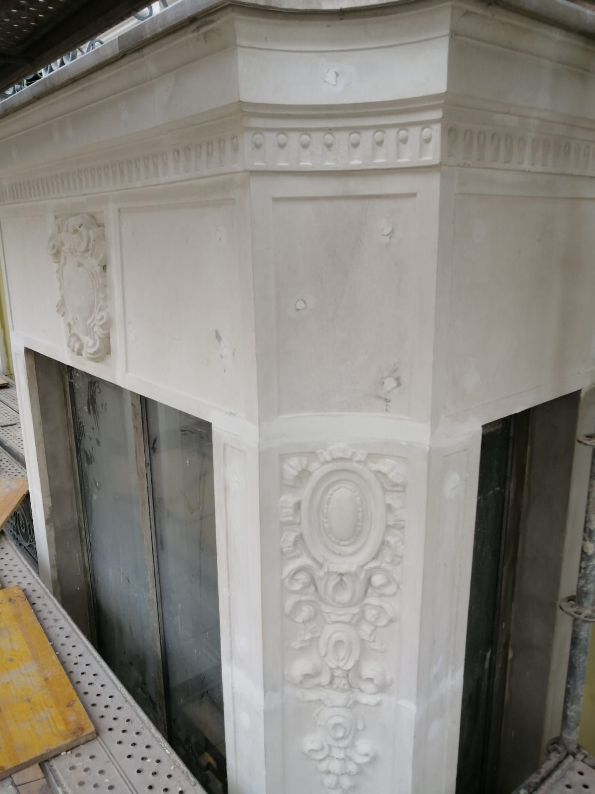 Esquina de una repisa de chimenea blanca y ornamentada en construcción.