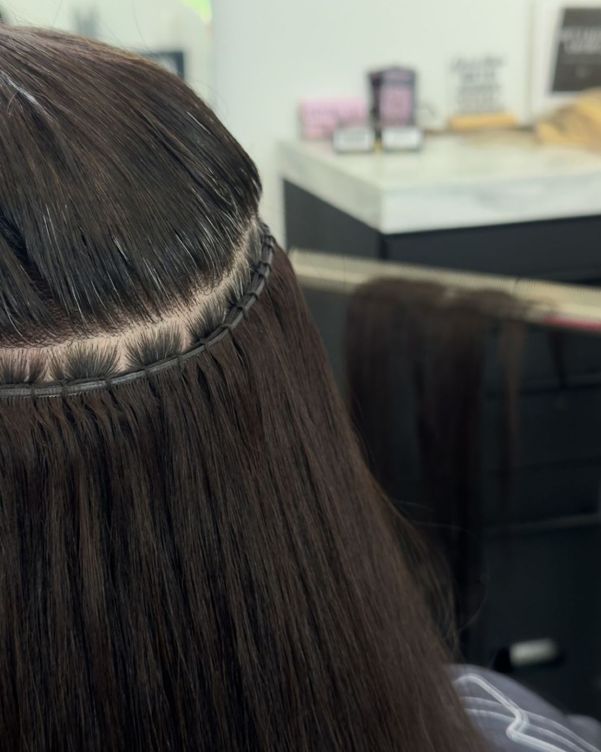 Extensiones de cabello rubio con pequeñas trenzas unidas al cabello natural, sujetadas con clips.