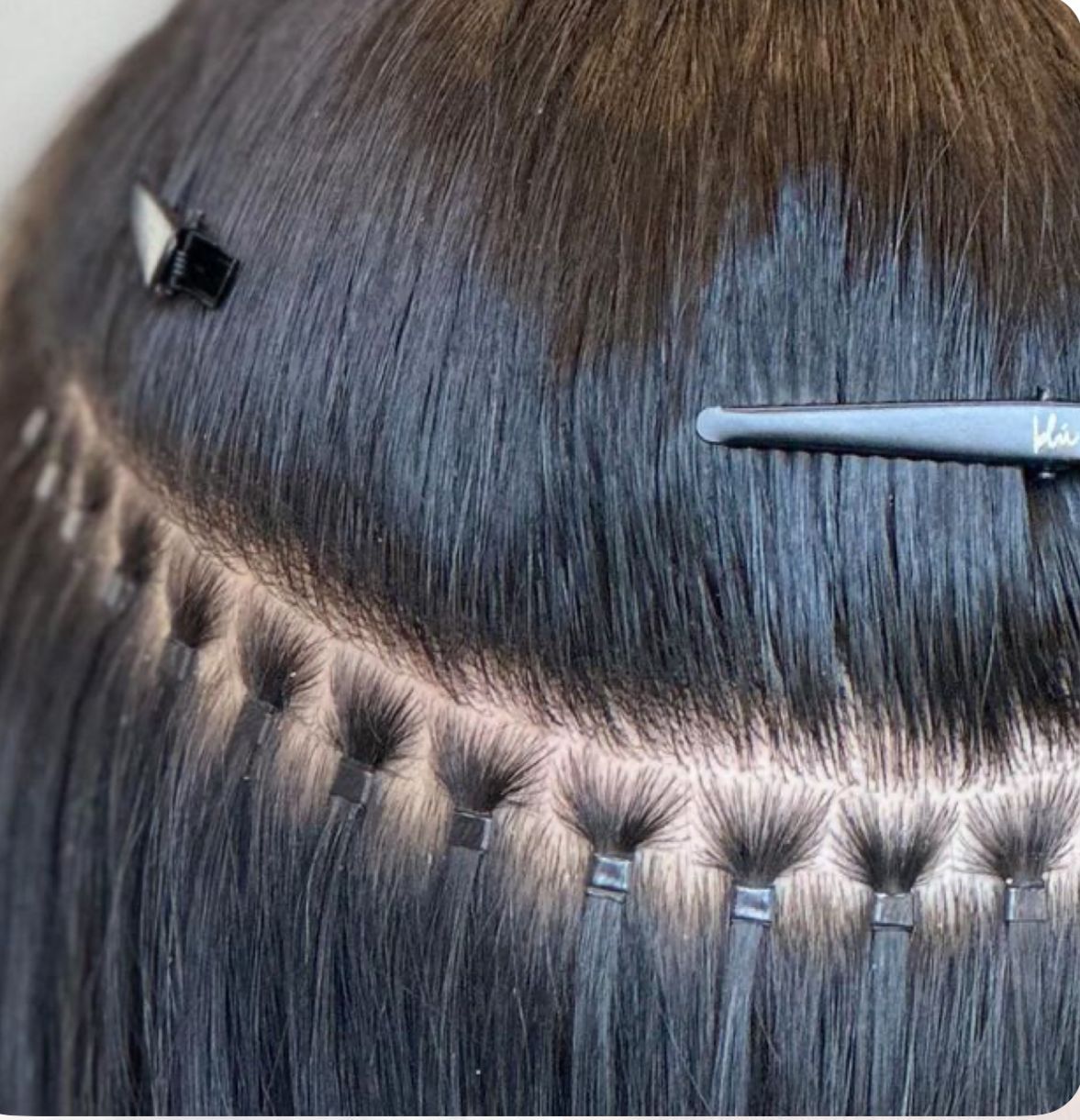 Extensiones de cabello rubio con pequeñas trenzas unidas al cabello natural, sujetadas con clips.