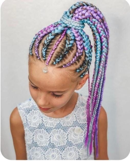Chica con cabello trenzado multicolor recogido en una coleta alta y con un top de encaje blanco.