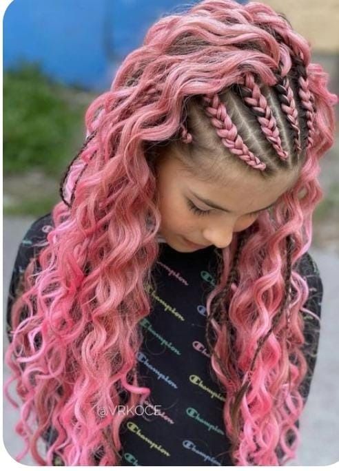 Chica con cabello rizado rosa y secciones trenzadas, vistiendo una sudadera negra.