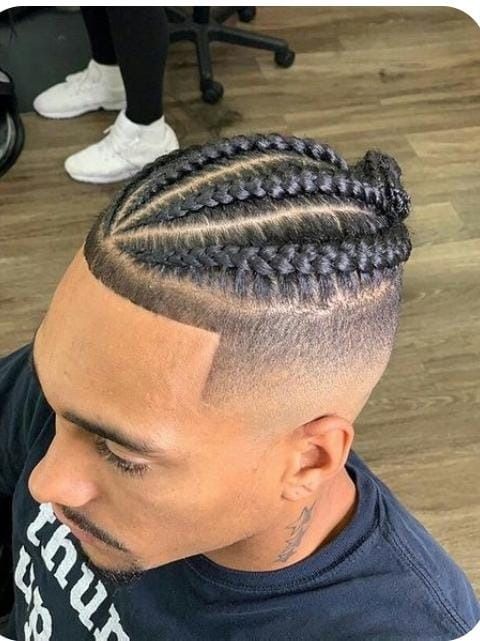 Hombre con peinado trenzado y corte de pelo degradado.