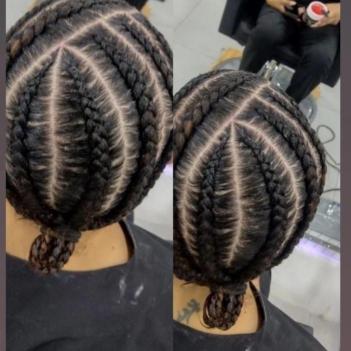 Primer plano de un peinado trenzado negro con un patrón geométrico, usado por una persona en el interior.