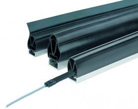 Tres tubos de goma negros con un cable unido a ellos sobre un fondo blanco.