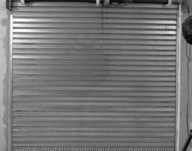 Una fotografía en blanco y negro de una puerta de garaje de metal.