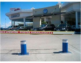 Un concesionario Volkswagen con muchos coches aparcados delante.