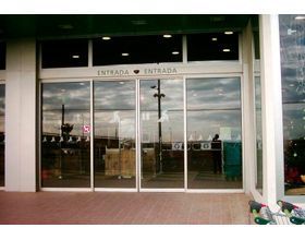 Una tienda con puertas corredizas de vidrio y un cartel que dice entrada