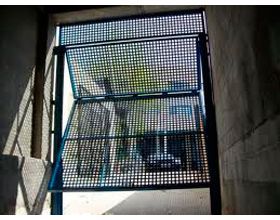 Una puerta azul está abierta a un garaje con un coche aparcado en él.