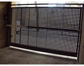 Una puerta corrediza con agujeros está abierta en una habitación.