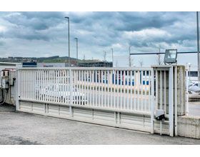 Una puerta corrediza con un coche aparcado detrás de ella en un estacionamiento.