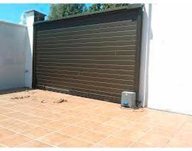 Hay una puerta de garaje corrediza con un motor conectado a ella.