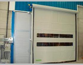 Una puerta rápida blanca con una pared azul en un almacén.