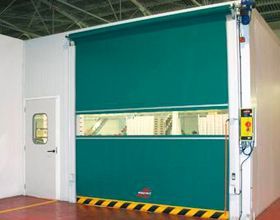 Una puerta rápida verde está abierta en una habitación.