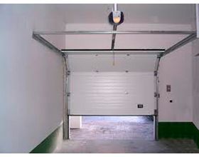 Una puerta de garaje con motor se abre en un garaje.