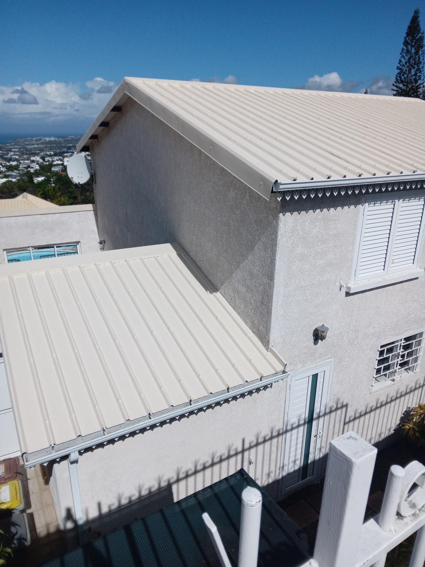 Bâtiment blanc au toit en tôle ondulée.