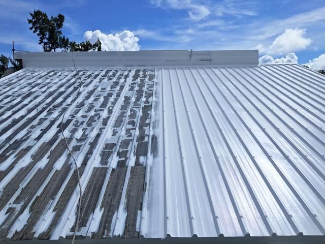 Toiture métallique partiellement nettoyée, révélant le contraste entre les parties abîmées par les intempéries et celles fraîchement peintes.