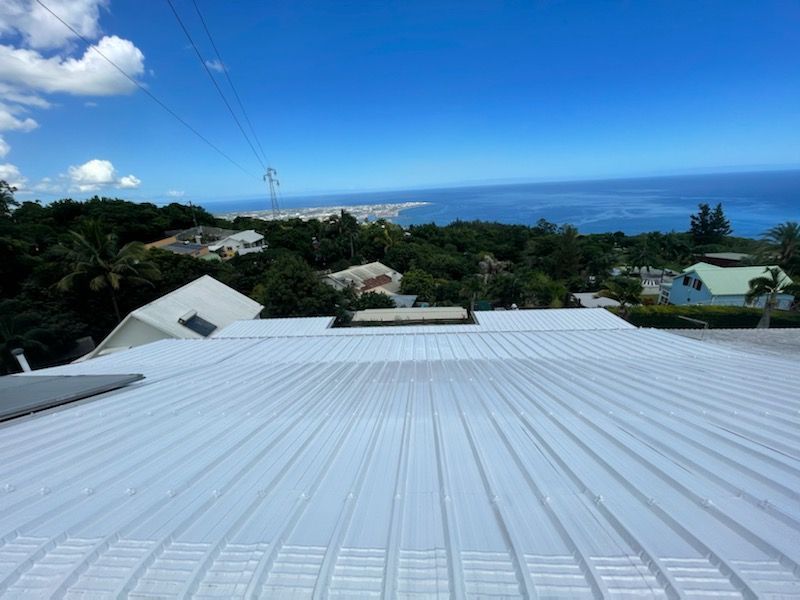 Vue depuis un toit métallique sur l'océan et la ville.