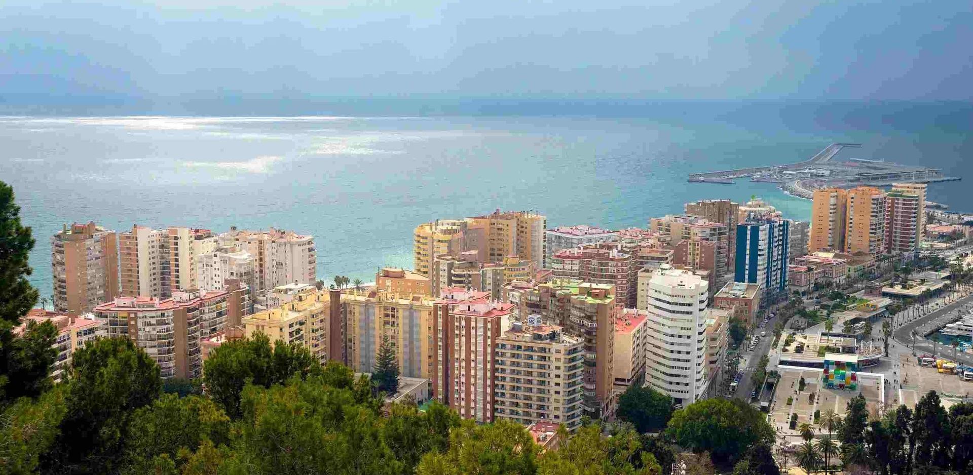 Una vista aérea de una ciudad rodeada de árboles y edificios junto al océano.