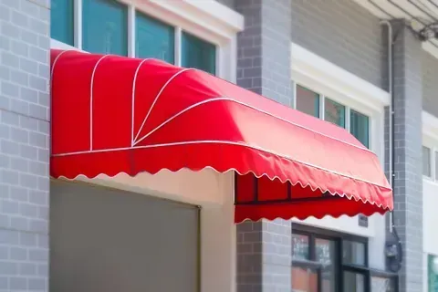 Un toldo rojo está en el costado de un edificio.