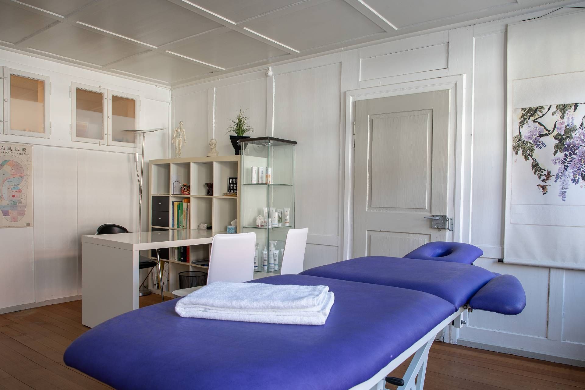 Hilfsmittel für die Schröpftherapie: Glasbecher, Nadeln, Handtuch und ein Moxibustionsstab auf einer violetten Unterlage.