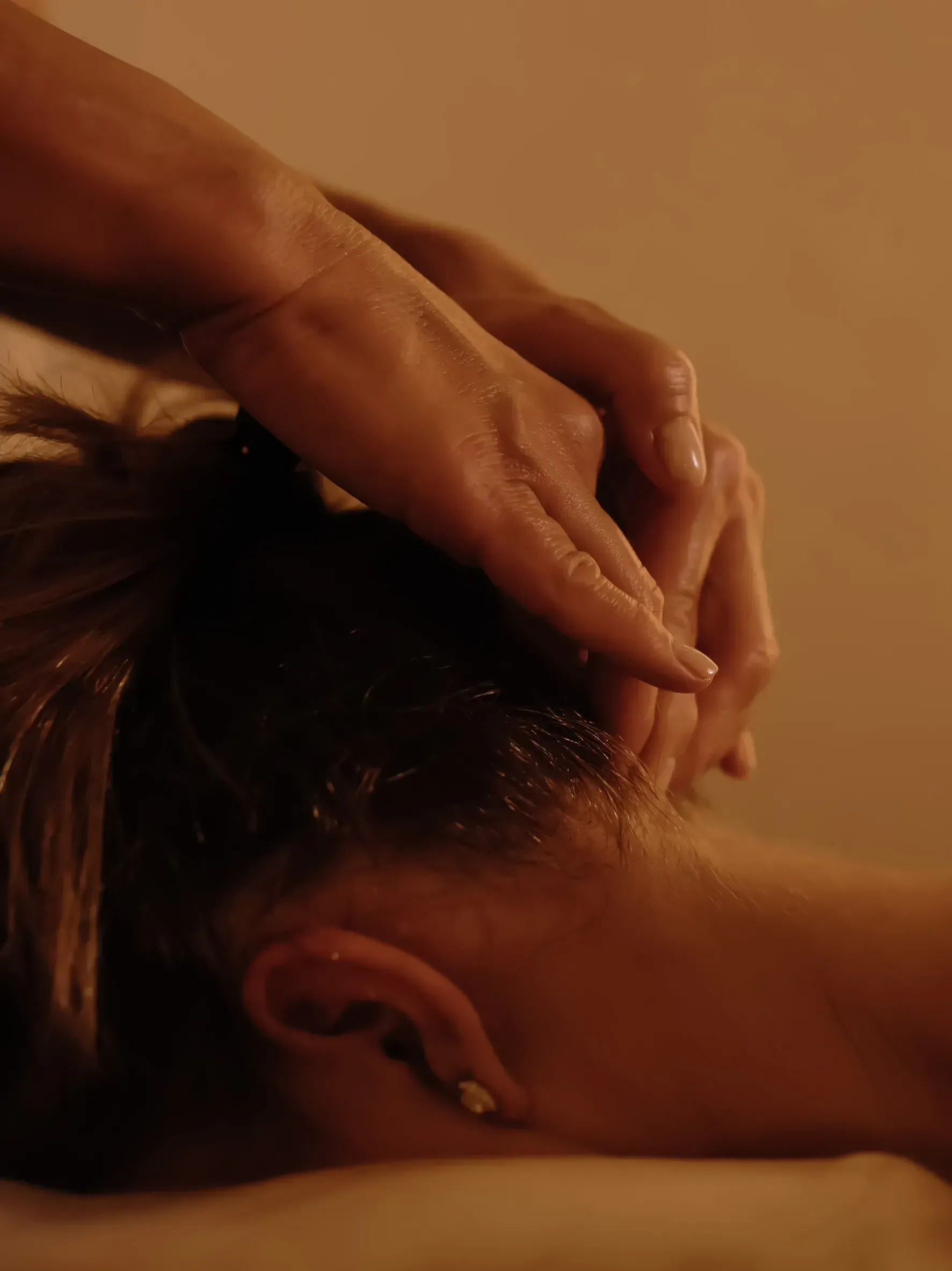 Mujer sonriendo, ajustando la tira del sujetador de encaje negro; sobre un fondo blanco.