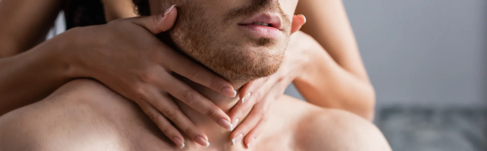 Manos acariciando suavemente un pecho y cuello desnudos.