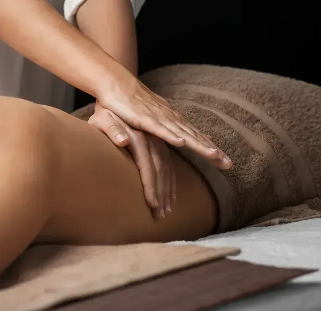 Manos masajeando una espalda desnuda. Primer plano de una sesión de terapia de masaje.