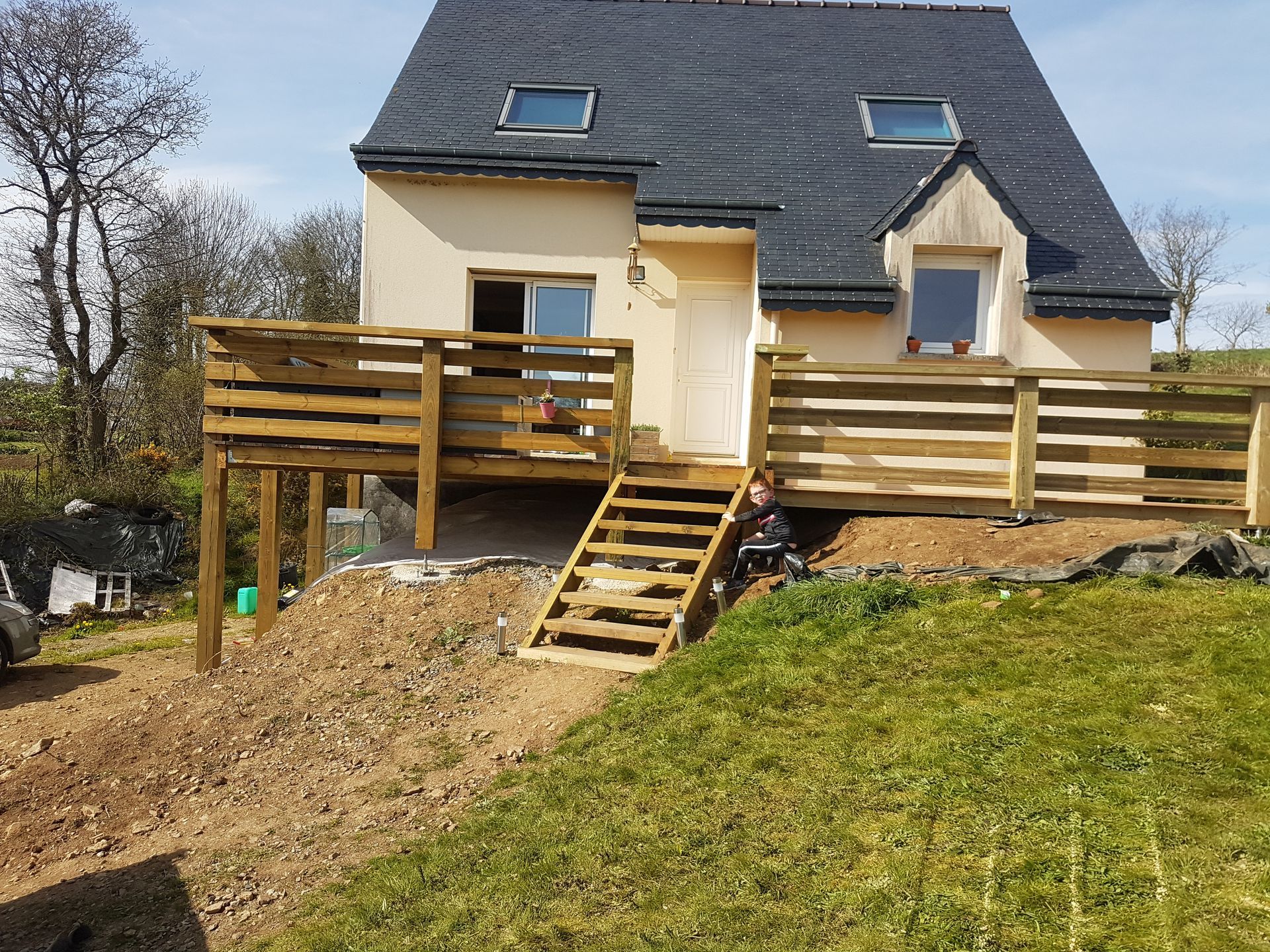 Maison sur un terrain avec une terrasse en bois sur mesure