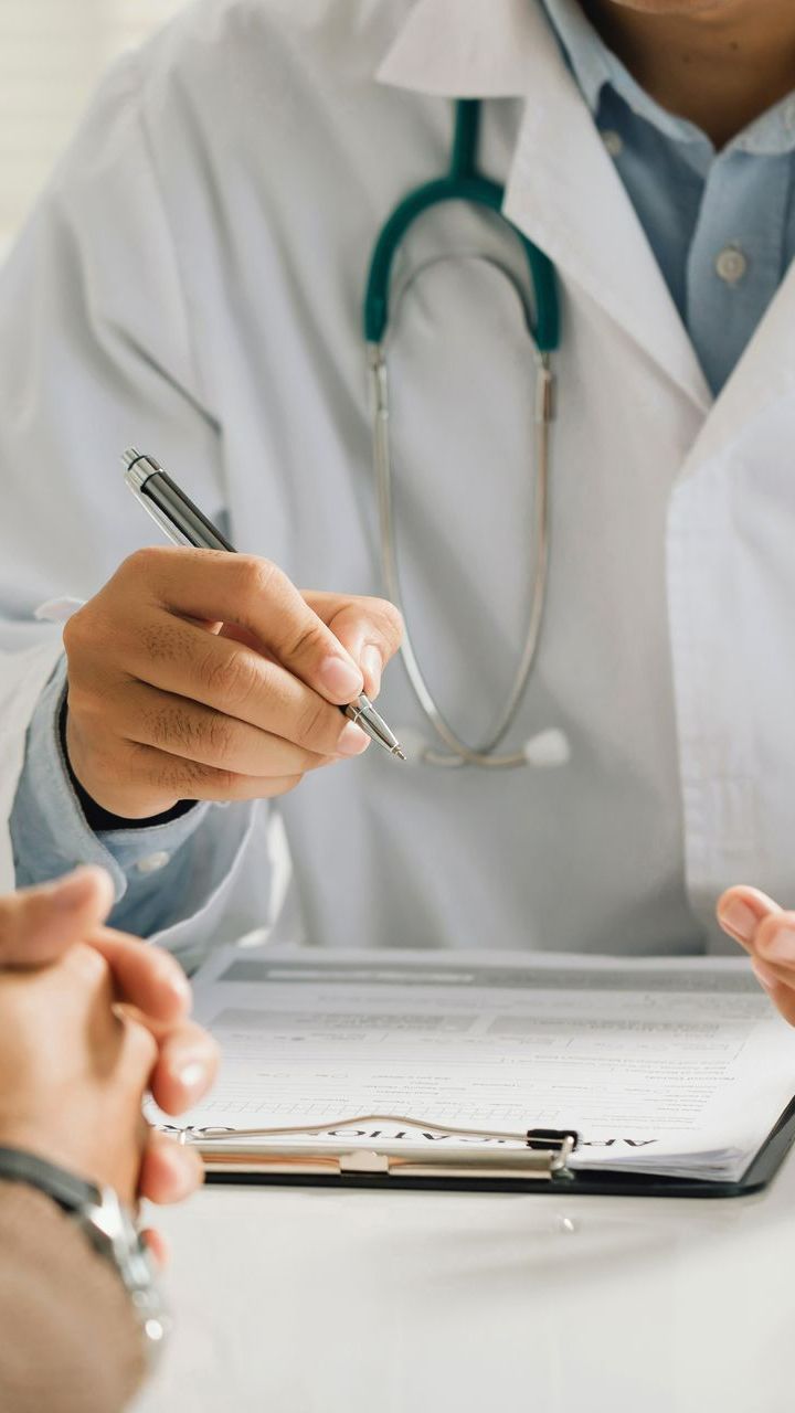 Le médecin note des informations sur le dossier du patient.