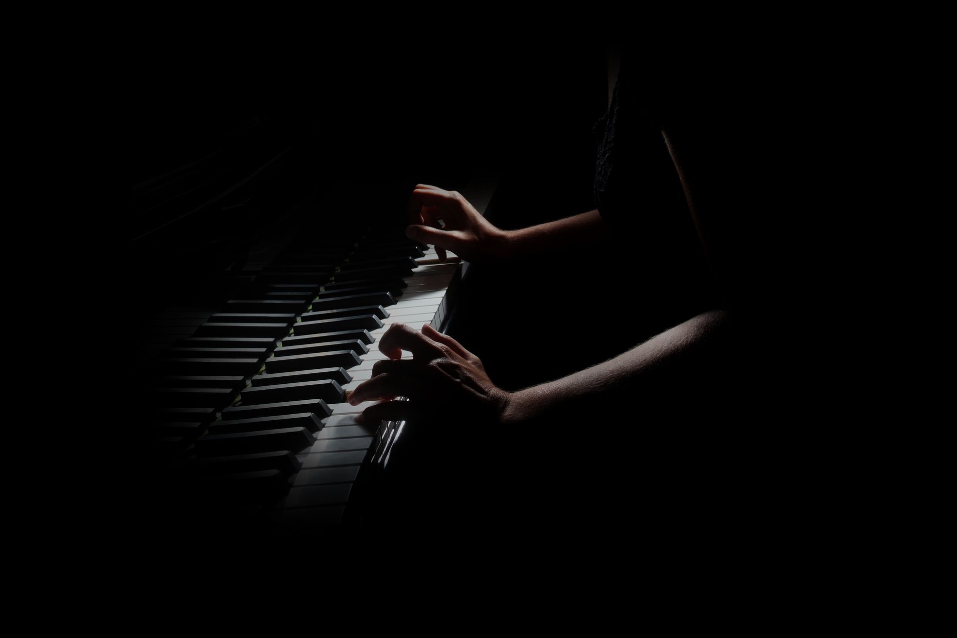 Photo sombre de deux mains féminines qui pianotent