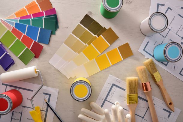 Des échantillons de couleurs, de peinture et des outils sont éparpillés dans un espace de travail de conception.