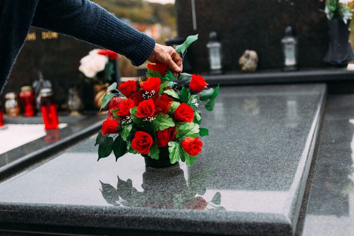 Bouquet de roses rouges sur une pierre tombale