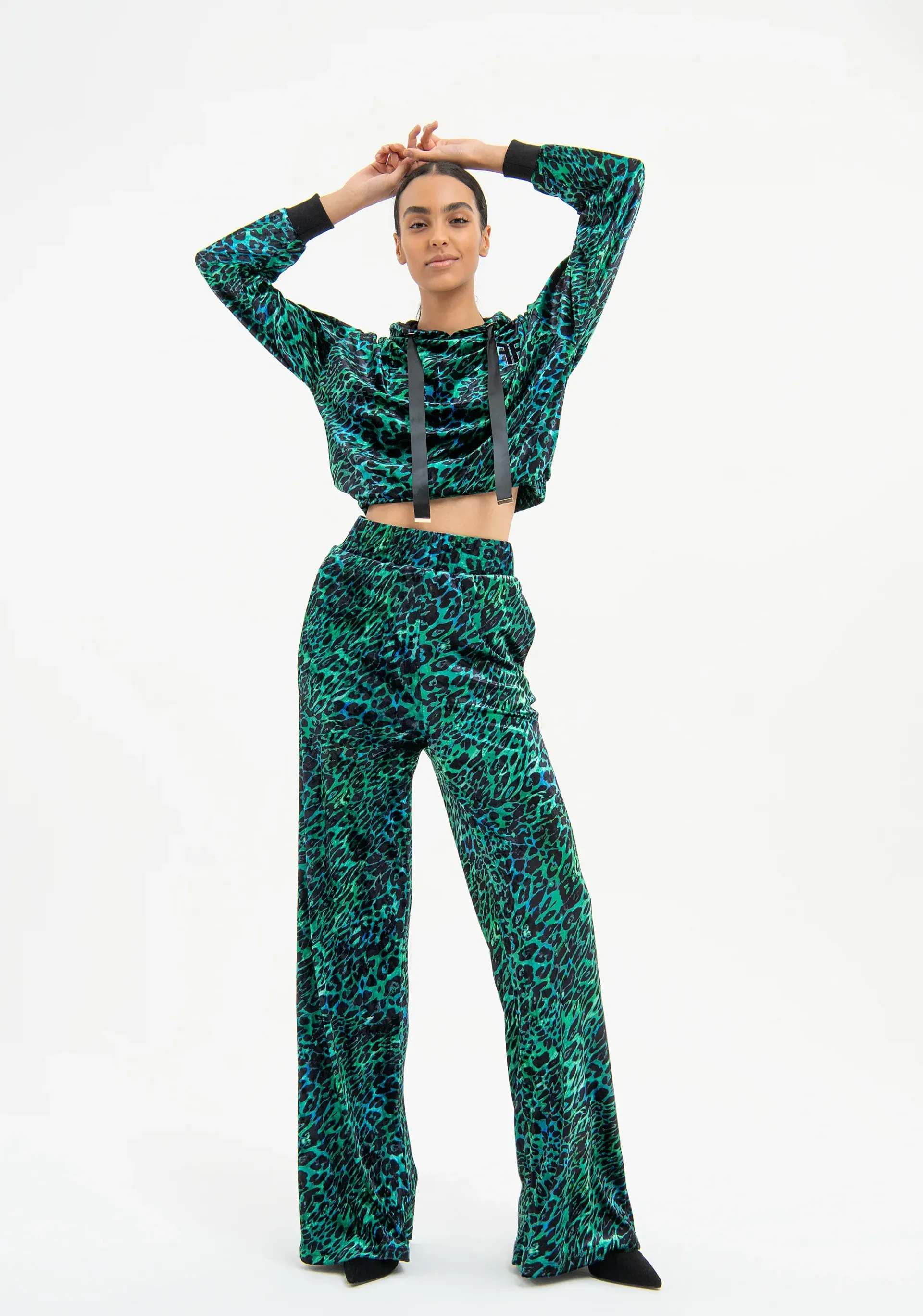 Une femme portant un ensemble avec haut court et pantalon évasé verts