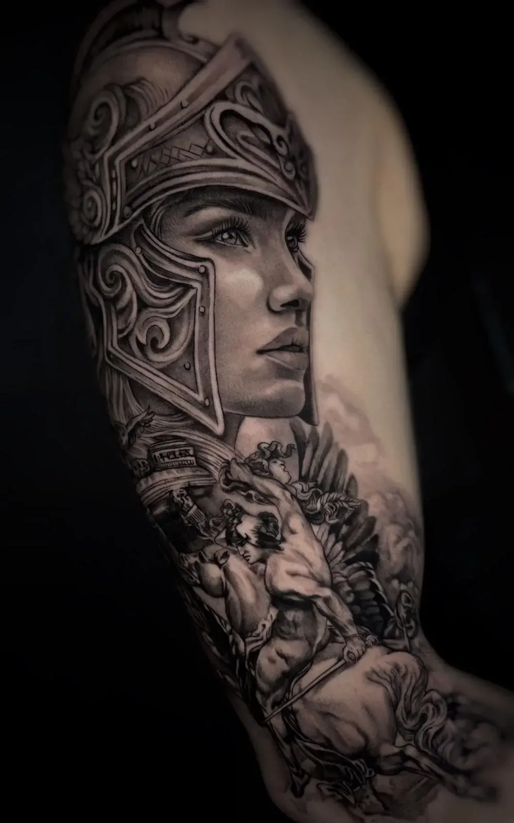 Tatuaje detallado en negro y gris del perfil de un guerrero con casco en un brazo