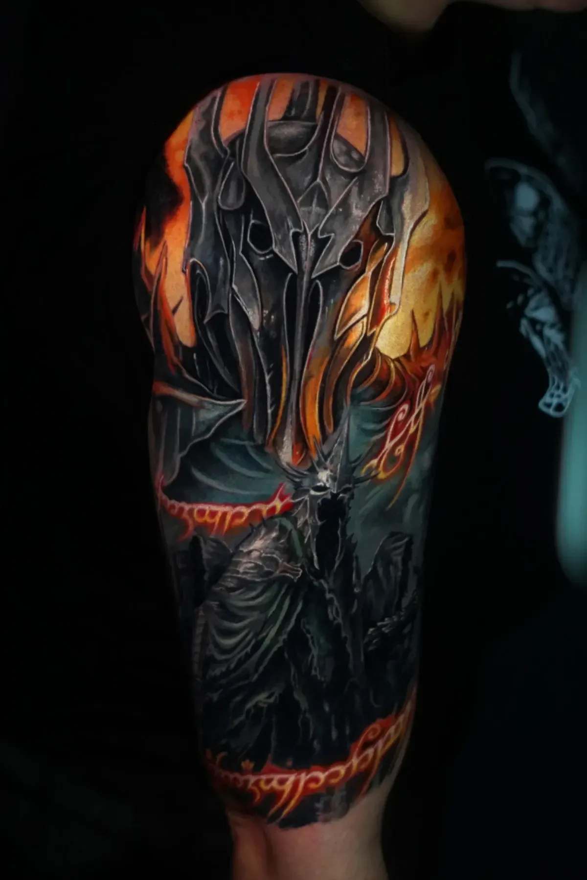 Primer plano de una manga de tatuajes oscuros y ardientes, con una calavera demoníaca y destellos naranjas brillantes
