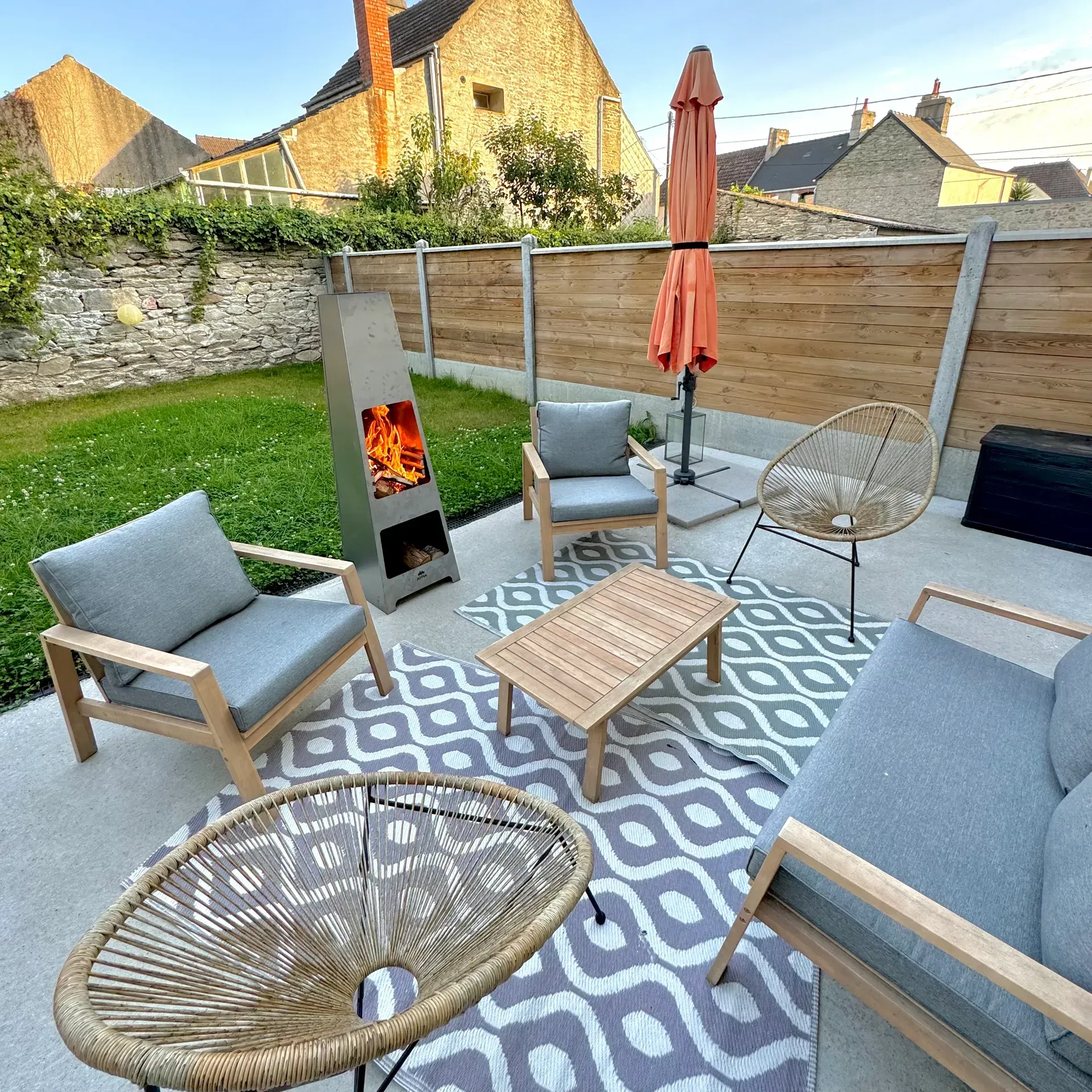 Un poêle extérieur au milieu d'un salon de jardin