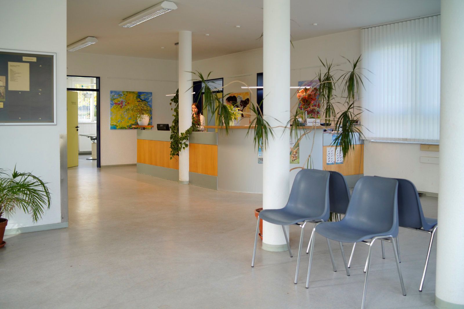 Ein Wartezimmer mit Stühlen und einer Pinnwand