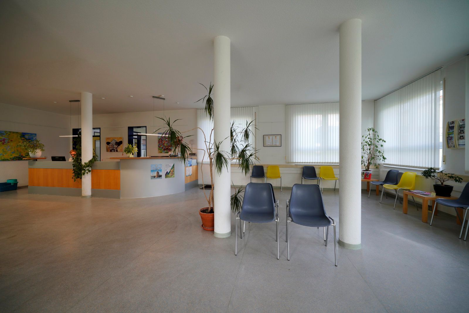 Ein Wartezimmer mit Stühlen und einem Tresen in einem Krankenhaus.